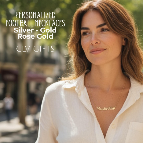 Woman in a white button-front blouse wearing a personalized football necklace outdoors.