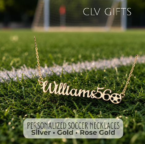 Gold-tone personalized name necklace with a soccer ball motif on a soccer field.